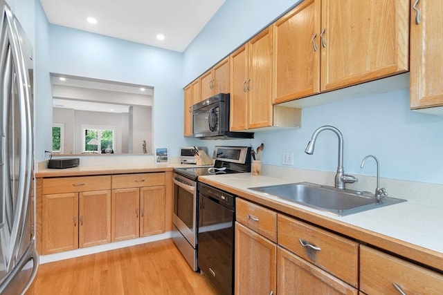 14 Michaels Grn Unit 14, Woburn, MA 01801 - kitchen featuring black appliances, light wood-style floors, light countertops, a sink, and recessed lighting