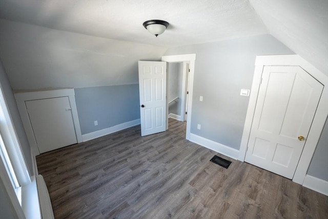 additional living space with lofted ceiling, wood finished floors, and baseboards