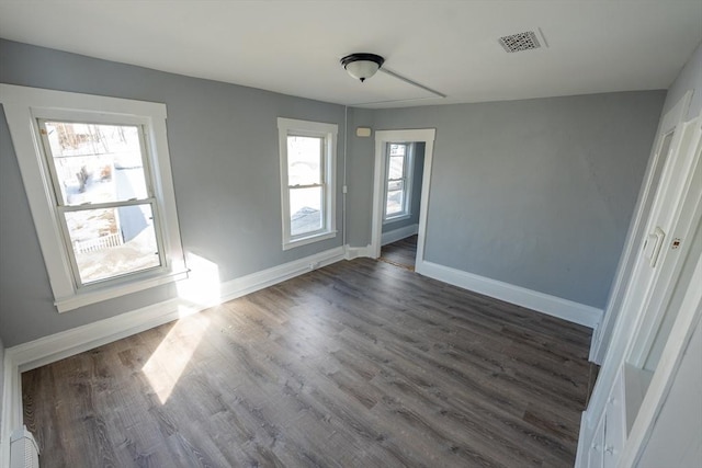 interior space featuring dark wood-style floors, visible vents, and baseboards