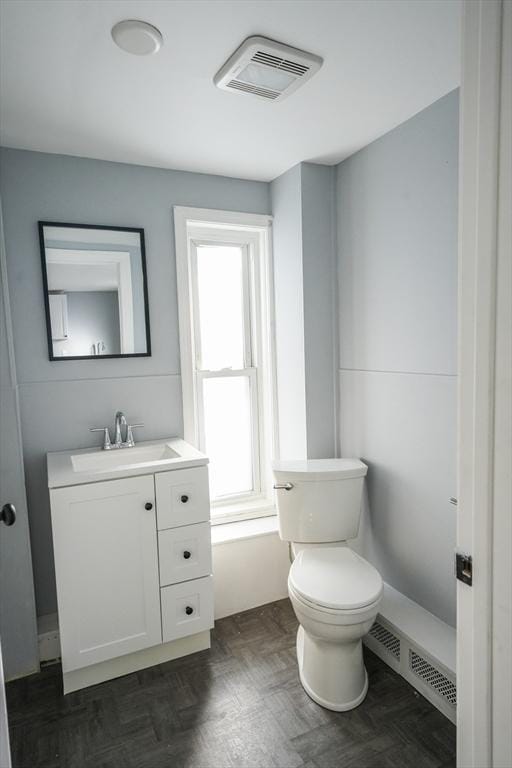 half bath featuring toilet, visible vents, and vanity