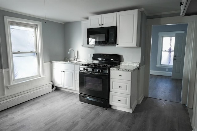 kitchen featuring a baseboard radiator, wood finished floors, a sink, white cabinetry, and black appliances