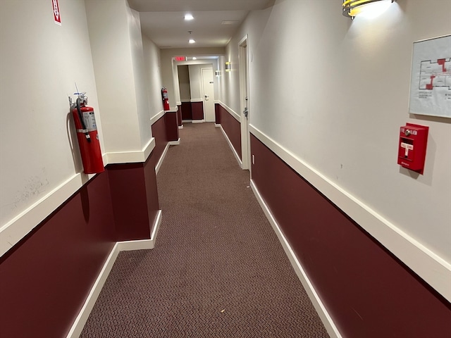 hallway with dark colored carpet