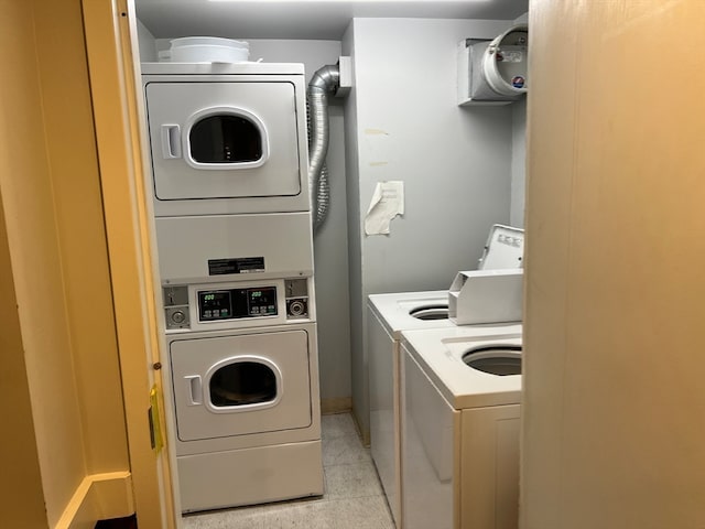 washroom with washing machine and clothes dryer, stacked washer and dryer, and light tile patterned flooring