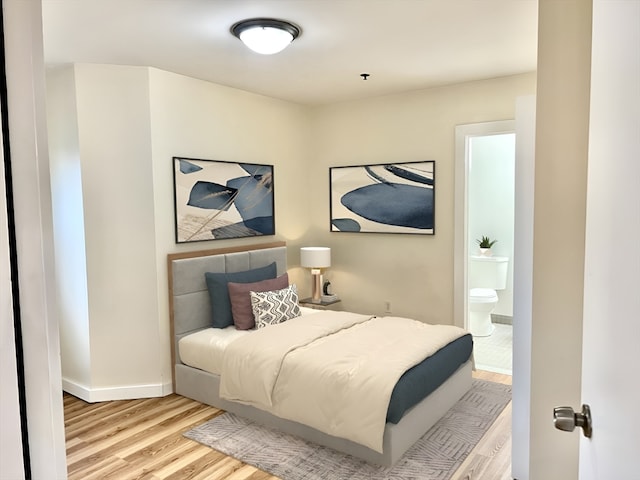 bedroom featuring light wood-type flooring and ensuite bathroom