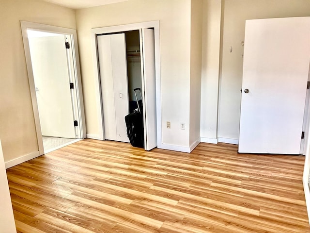 unfurnished bedroom with light hardwood / wood-style flooring and a closet