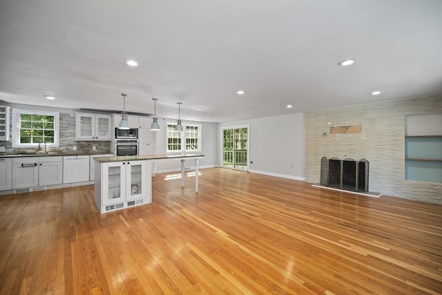 34 Clubhouse Ln, Natick, MA 01760 - unfurnished living room with light wood finished floors, a fireplace, and recessed lighting