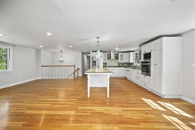 34 Clubhouse Ln, Natick, MA 01760 - kitchen featuring stainless steel appliances, wall chimney exhaust hood, recessed lighting, decorative backsplash, and light wood-type flooring