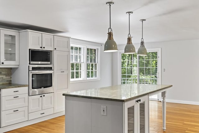 34 Clubhouse Ln, Natick, MA 01760 - kitchen featuring appliances with stainless steel finishes, plenty of natural light, glass insert cabinets, and light wood-style floors