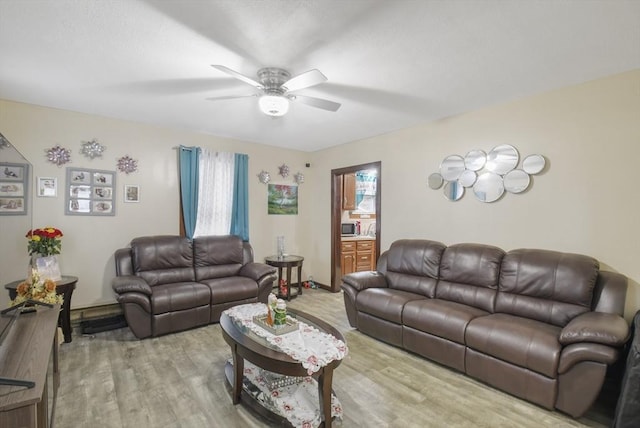 living area with a ceiling fan and wood finished floors