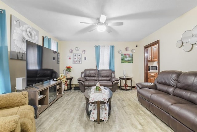 living area with light wood-type flooring and ceiling fan