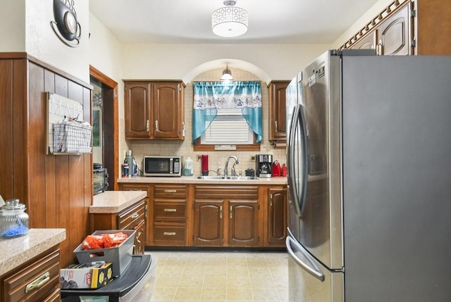 kitchen with light countertops, tasteful backsplash, appliances with stainless steel finishes, and a sink