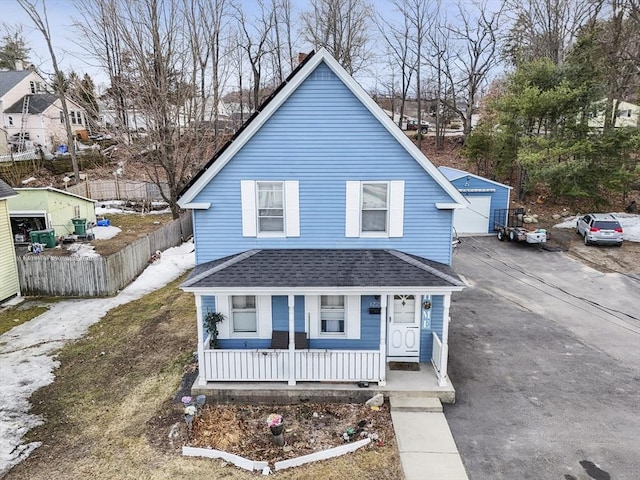 view of front of home with a shingled roof, fence, a porch, a garage, and driveway