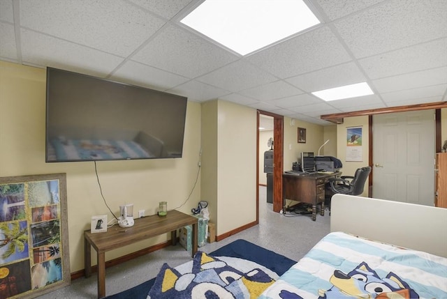 bedroom with baseboards and a drop ceiling