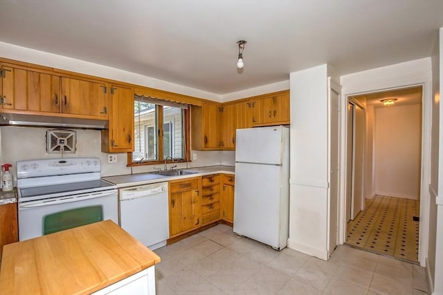 112 Harmon Ave, Springfield, MA 01118 - kitchen with white appliances, under cabinet range hood, light countertops, brown cabinetry, and light tile patterned floors