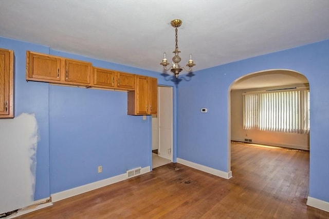 112 Harmon Ave, Springfield, MA 01118 - spare room with arched walkways, dark wood finished floors, and a chandelier