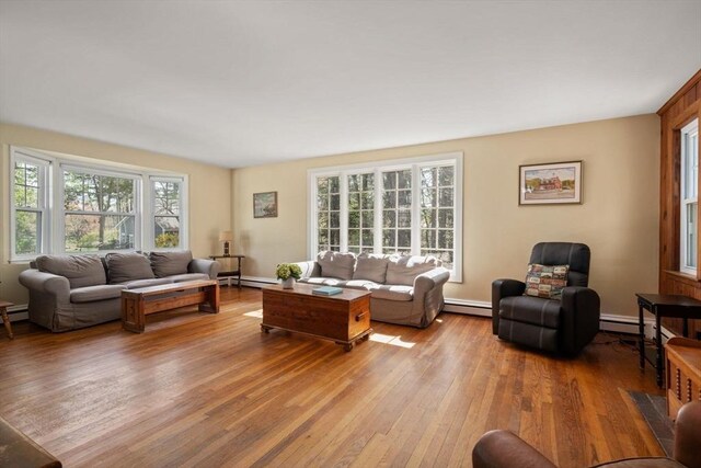 living area with hardwood / wood-style flooring and a baseboard heating unit