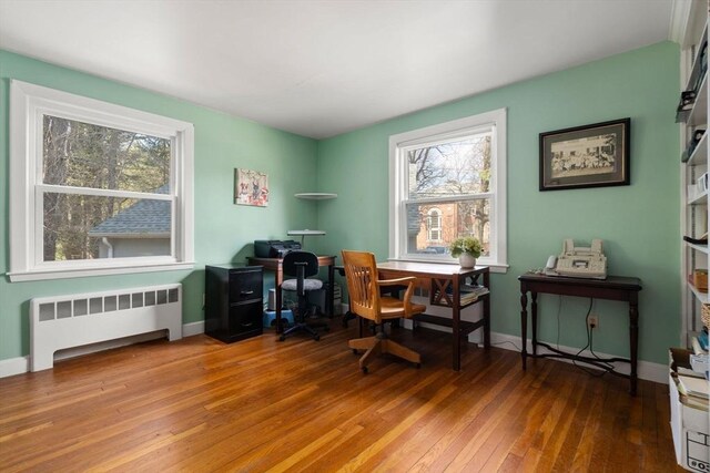 office featuring radiator heating unit, hardwood / wood-style flooring, and baseboards