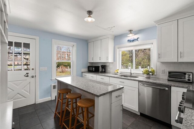 kitchen featuring a sink, appliances with stainless steel finishes, backsplash, and plenty of natural light