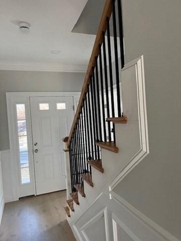 foyer featuring light hardwood / wood-style floors and crown molding