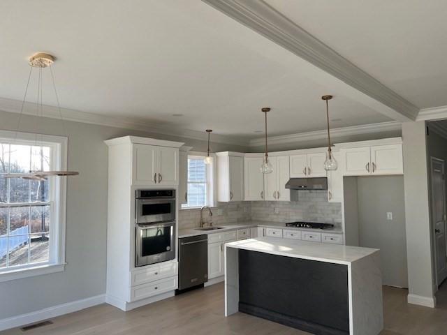 kitchen featuring dishwasher, gas stovetop, pendant lighting, sink, and white cabinetry