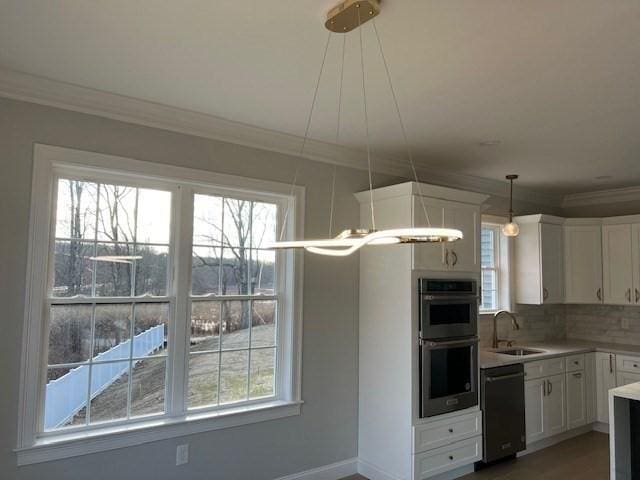 kitchen with dishwasher, stainless steel double oven, white cabinets, decorative light fixtures, and sink