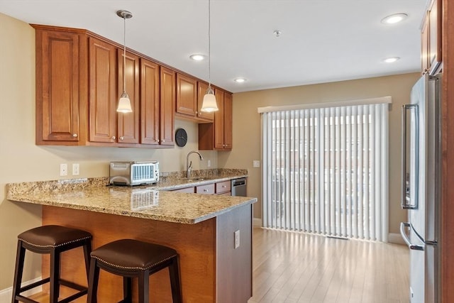 15 Coates Ln Unit 15, Haverhill, MA 01835 - kitchen with freestanding refrigerator, a peninsula, a sink, light wood-style flooring, and baseboards