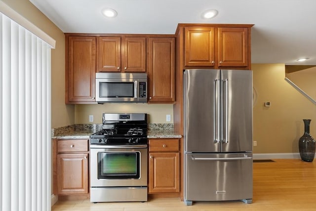 15 Coates Ln Unit 15, Haverhill, MA 01835 - kitchen with stainless steel appliances, light stone countertops, light wood finished floors, brown cabinets, and recessed lighting