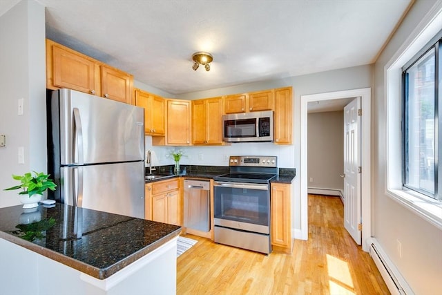 7 Mortimer Pl Unit 6, Somerville, MA 02145 - kitchen with appliances with stainless steel finishes, a baseboard heating unit, light wood finished floors, and light brown cabinetry