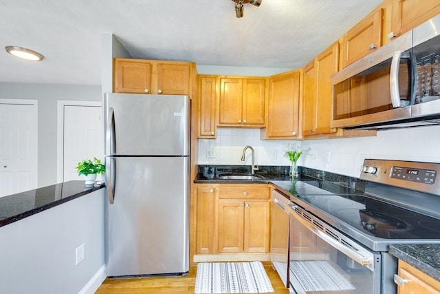 7 Mortimer Pl Unit 6, Somerville, MA 02145 - kitchen with appliances with stainless steel finishes, light wood finished floors, dark stone countertops, and backsplash