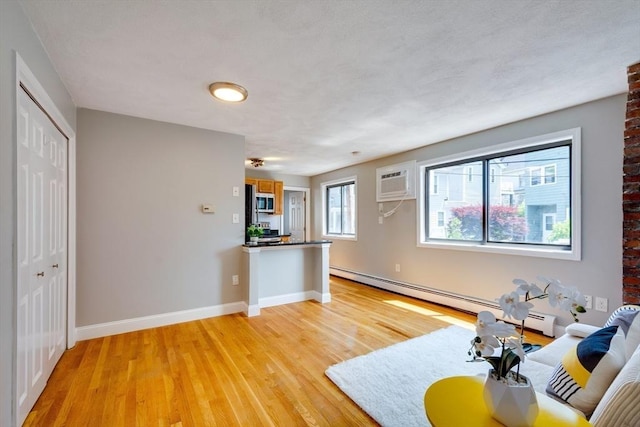 7 Mortimer Pl Unit 6, Somerville, MA 02145 - living area featuring a baseboard radiator, light wood-type flooring, and an AC wall unit