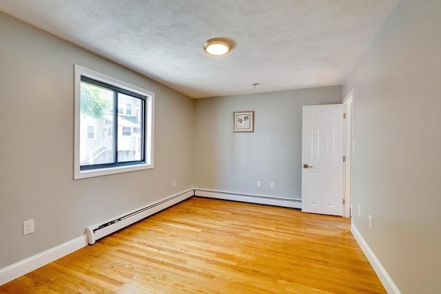 7 Mortimer Pl Unit 6, Somerville, MA 02145 - unfurnished room with a baseboard heating unit, light wood finished floors, and a textured ceiling