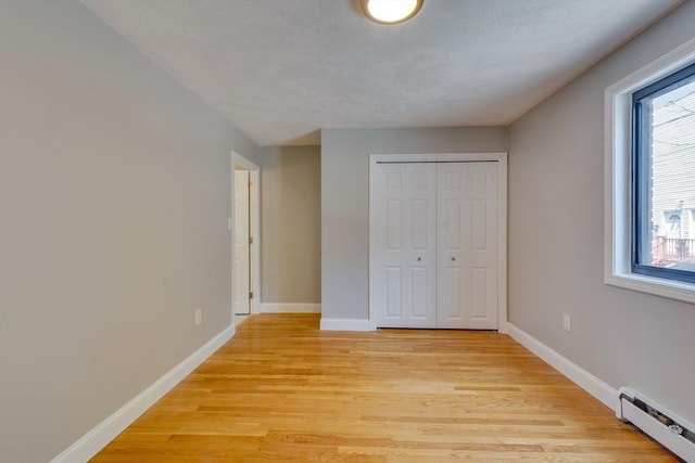 7 Mortimer Pl Unit 6, Somerville, MA 02145 - unfurnished bedroom featuring a baseboard radiator, light wood-style flooring, and a closet