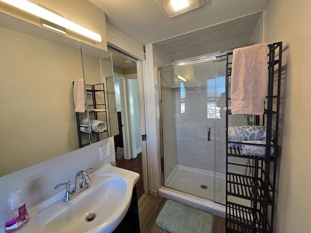 full bath with vanity, visible vents, wood finished floors, and a stall shower