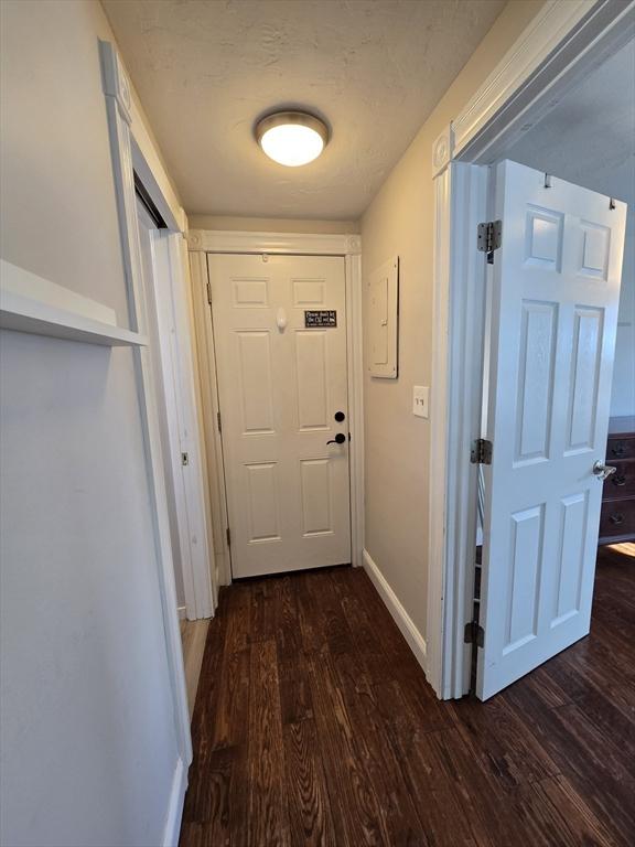 doorway to outside featuring baseboards and wood finished floors