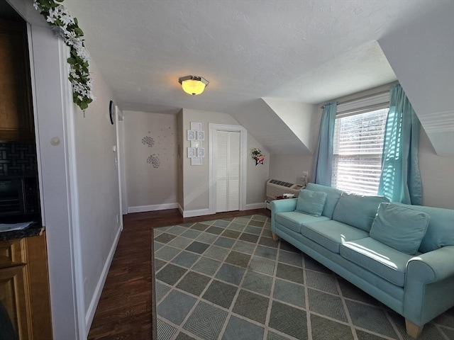 living area featuring baseboards, vaulted ceiling, a textured ceiling, a wall mounted AC, and dark wood-style flooring