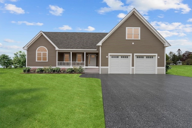 view of front of house with covered porch, a front yard, and a garage