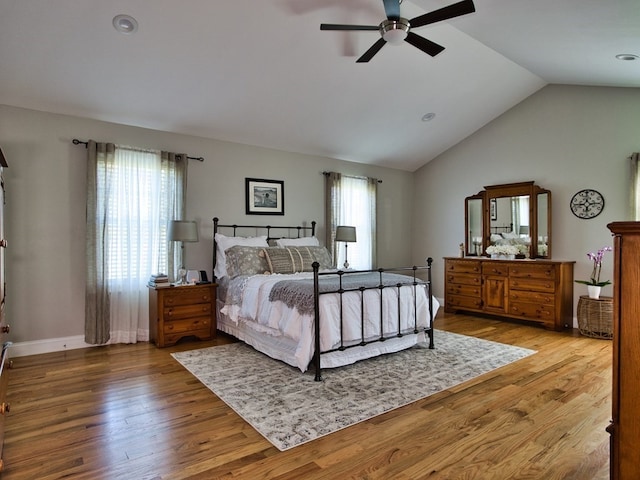 bedroom with lofted ceiling, ceiling fan, and light wood-type flooring