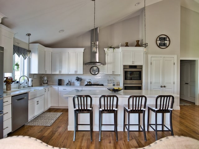 kitchen featuring sink, range hood, white cabinets, stainless steel appliances, and dark wood-type flooring