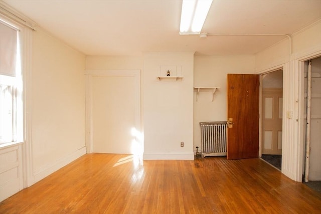 unfurnished room featuring wood-type flooring and radiator