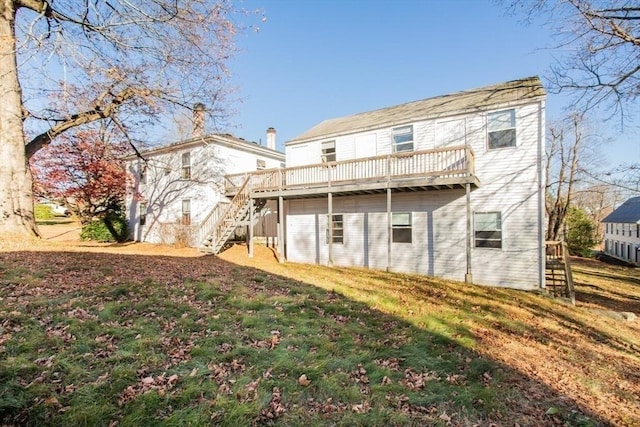 back of house with a deck and a yard