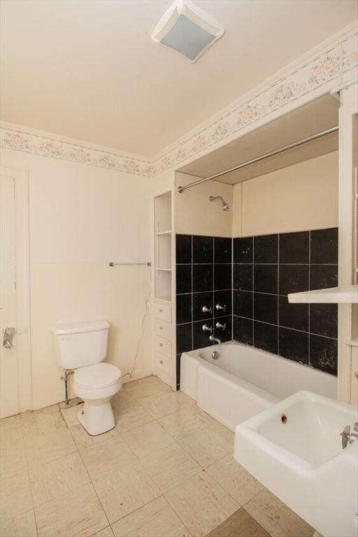 bathroom featuring toilet and washtub / shower combination