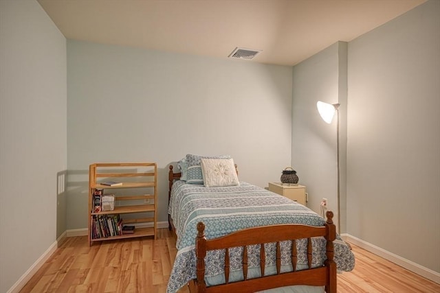 bedroom with light wood-style floors, baseboards, and visible vents