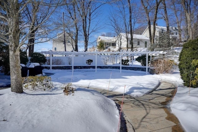 yard layered in snow with a pergola