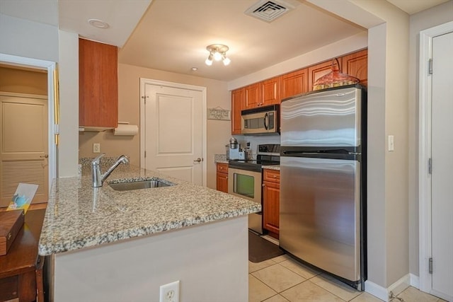 kitchen with light stone counters, visible vents, stainless steel appliances, and a sink