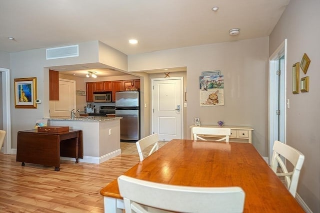 dining area featuring light wood-style floors, recessed lighting, visible vents, and baseboards