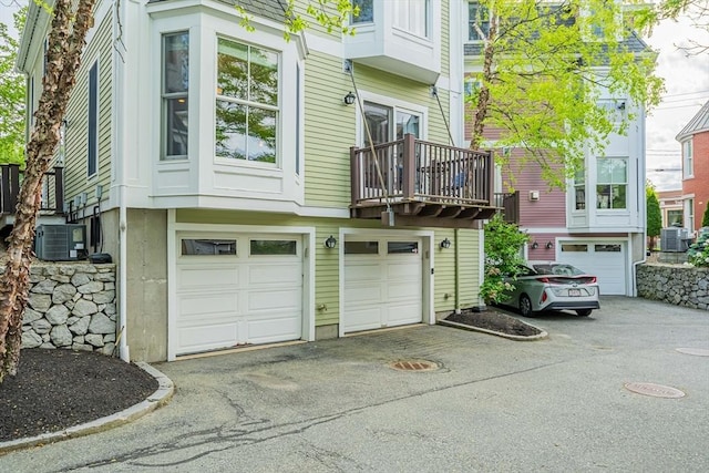 745-A Massachusetts Ave Unit A, Arlington, MA 02476 - rear view of property featuring asphalt driveway, a garage, and cooling unit