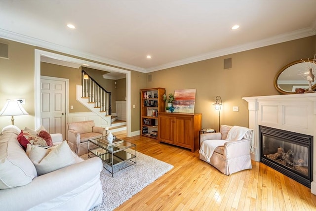 745-A Massachusetts Ave Unit A, Arlington, MA 02476 - living room featuring stairs, light wood-style floors, a glass covered fireplace, ornamental molding, and recessed lighting