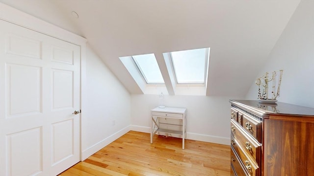 bonus room with light hardwood / wood-style flooring and vaulted ceiling with skylight