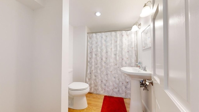 bathroom with toilet and wood-type flooring