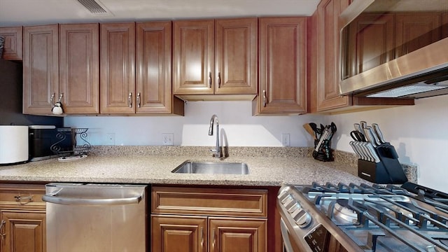 kitchen featuring light stone countertops, sink, and appliances with stainless steel finishes